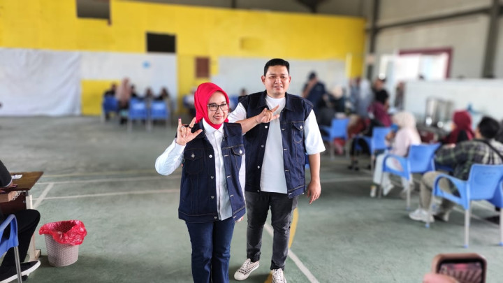 Kenakan Rompi Levis, Najirah Ditemani Putranya Mencoblos di TPS 005 Bontang Baru